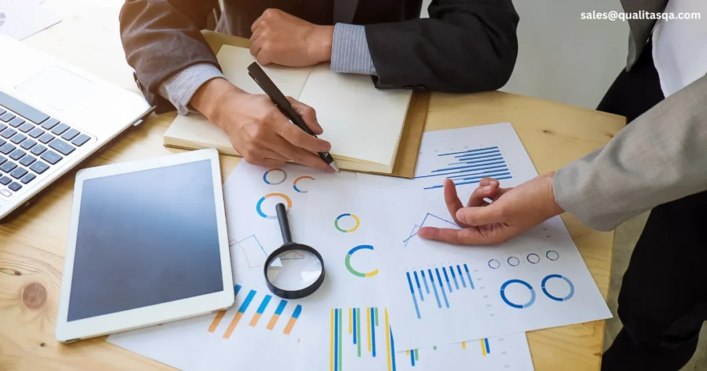 HR professionals looking at charts, reports and business documents during an Internal Audit Checklist for HR Department meeting to review employee records, HR compliance, workplace policies and internal audit processes.