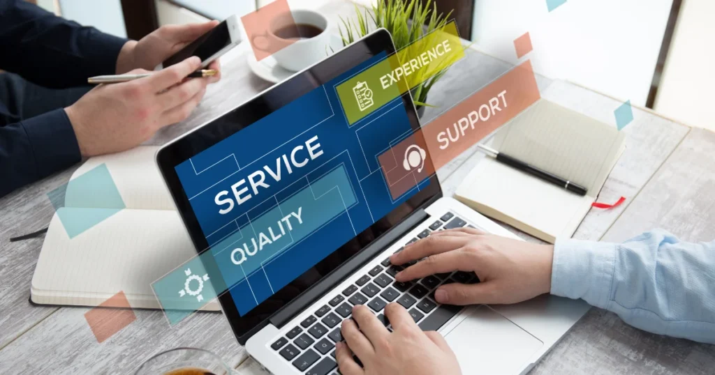 Team members huddled around a laptop, talking about service, quality, experience, and support, all backed by professional SOP writers who help companies build clear, standardised procedures. That’s how businesses hit real consistency. 