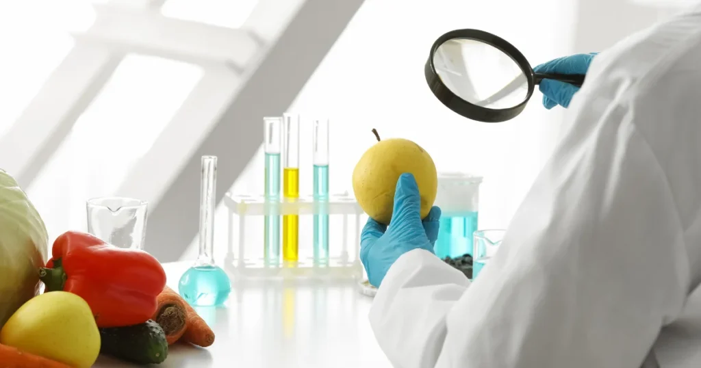 
Food safety professional examining fresh produce in a laboratory as part of HACCP Certification in Qatar and food hazard control procedures.